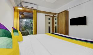 科泽科德Abrigo Delamar的卧室配有白色的床和平面电视。