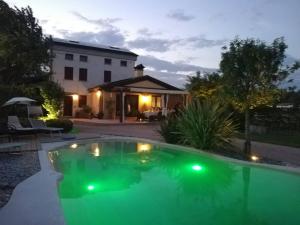 Sarcedo[Marostica - Villa with Swimming Pool] Netflix - WiFi的一座房子前的游泳池,拥有绿色的灯光