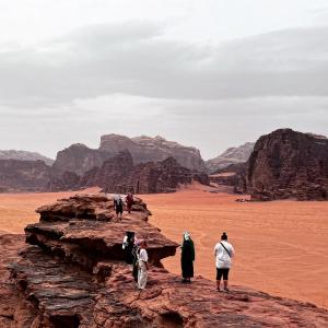 瓦迪拉姆Bedouin Tribe Camp Wadi Rum的一群人站在沙漠的岩石上