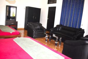 马纳尔Thalladi Holiday Bungalow的一间卧室配有两张黑色皮椅和一张床