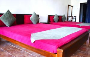 马纳尔Thalladi Holiday Bungalow的配有粉红色床单的客房内的两张床