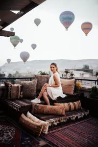 格雷梅皇家石屋 - 格雷梅的坐在带热气球的沙发上的身着白色衣服的女人