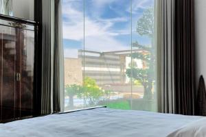 达卡Grand Villa Oasis的一间卧室设有一张床和一个大窗户