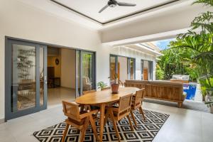 坎古Villa Royal Canggu - 3 minutes to FINNS Beach club!的一间带木桌和椅子的用餐室