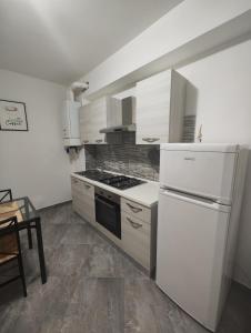 诺瓦拉appartamento C&Y Ghiberti的厨房配有炉灶和白色冰箱。
