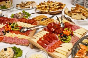 梅特科维奇Hotel Narona的餐桌上摆放着许多不同种类的肉类和奶酪