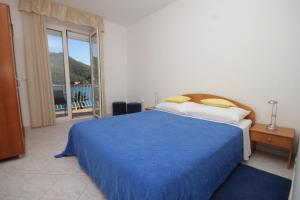 斯拉诺Apartments by the sea Slano, Dubrovnik - 8538的一间卧室设有蓝色的床和一个阳台