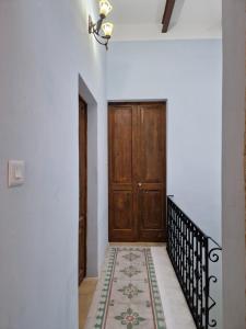 Għajn il-KbiraSir Patrick's rooms & hostel的走廊上设有木门和地毯