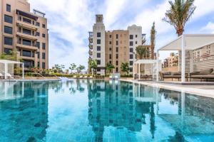 迪拜Livbnb Suites - Madinat Jumeirah Living - Cozy 2 Bedroom near Burj Al Arab的一座大型游泳池,其建筑背景为: