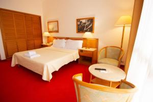 地拉那Chateau Linza Resort的酒店客房带一张床、一张桌子和椅子