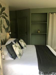 阿宰勒里多Logis Hôtels Troglododo的一间卧室配有一张带绿色墙壁和书架的床