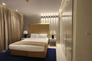 迪拜DAMAC Voleo In Business Bay的一间卧室配有一张大床和两盏灯。