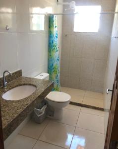 瓜拉派瑞Casa na praia d’Ulé的浴室配有卫生间、盥洗盆和淋浴。