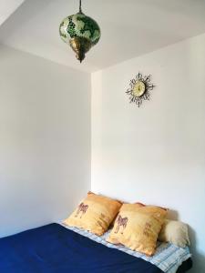 马德里Homenfun Madrid Villaverde Bajo的一间卧室配有一张带枕头的床和吊灯。
