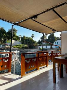 Nag` el-RamlaHouseboat Hotel and Nile Cruises Zainoba的船上配有桌子,享有水景