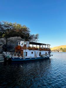 Nag` el-RamlaHouseboat Hotel and Nile Cruises Zainoba的一艘白船停靠在水中