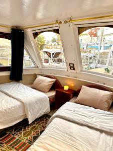 Nag` el-RamlaHouseboat Hotel and Nile Cruises Zainoba的带2扇窗户的客房内的2张床