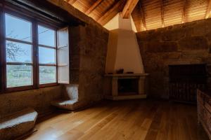 AmoeiroHabitaciones con baño individual en Casa de campo. Piscina.的客厅设有壁炉和大窗户。