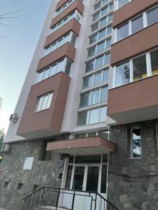 代温Апартамент Рая的一栋高高的公寓大楼,拥有石制外观