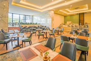 日惹Grand Kangen Hotel Urip Sumoharjo的一间带桌椅的餐厅和一间自助餐厅