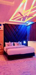 艾哈迈达巴德Hotel Primeland villa Gota的紫色客房内的一间卧室,配有一张床