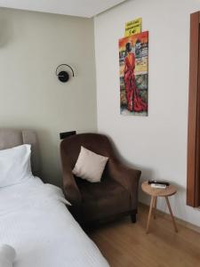 塞费里希萨尔SIĞACIK SEN KONUK EVİ的一间卧室配有一张床、一把椅子和一张海报