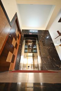 PunjalkatteHotel Rays Inn Boarding and Lodging的一条空的走廊,铺着瓷砖地板,设有楼梯