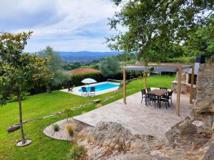 巴伦西亚Casa de Gandra的一个带桌椅的庭院和一个游泳池