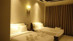 贡布Suorsdei Boutique的酒店客房,配有两张带白色床单的床