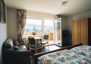 比尔弗登斯帕尔特沃尔德旅馆的一间卧室配有一张床、一张桌子和一个窗户。