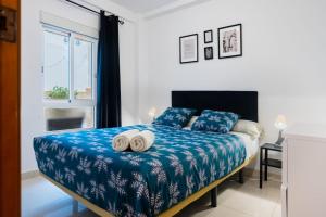 塞维利亚San Pagés 3BR Apartment的一间卧室配有一张床,上面有两条毛巾
