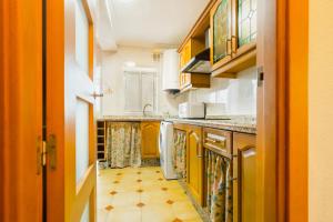 塞维利亚San Pagés 3BR Apartment的厨房设有黄色橱柜和地板