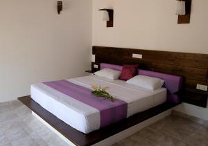 本托塔Sanda Eliya Resort的一间卧室配有一张带鲜花的大床