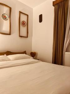 博尔沙Cabana Bogdi的卧室配有一张床和墙上的2个盘子