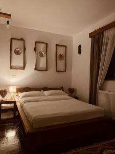 博尔沙Cabana Bogdi的一间卧室配有一张床,墙上挂着一些图片