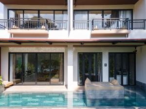 董里Kachonghills Tented Resort Trang的房屋前有游泳池的房子