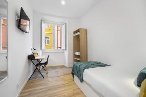 里斯本Smart Living Hub: Designer Spaces for Digital Nomads & Remote Workers的白色卧室配有床和书桌