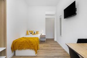里斯本Smart Living Hub: Designer Spaces for Digital Nomads & Remote Workers的一间卧室配有一张黄色毯子床