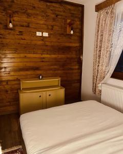 博尔沙Cabana Bogdi的一间卧室设有一张床和木墙