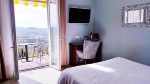 阿尔巴Villa Bellavista Alba, B&B的一间卧室设有一张床,阳台配有电视。