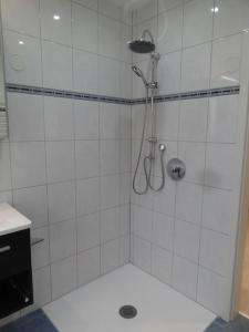 本德Idyllisch gelegene EG-Wohnung m. 3 Schlafzimmern的白色瓷砖浴室内的淋浴