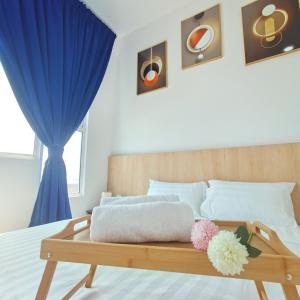 马六甲Amber Cove Seaview I MUJI 2BR I Game Room I 3-9pax的一间卧室配有一张带蓝色窗帘的木床