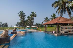 UtordaKenilworth Resort & Spa, Goa的度假村的游泳池,有人坐在里面