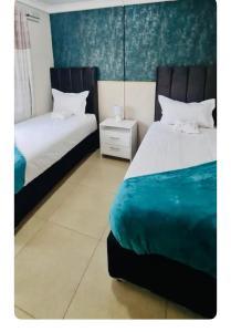 哈拉雷Beautiful 3-Bed House in Harare的一间卧室设有两张床和床头柜