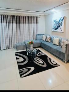 哈拉雷Beautiful 3-Bed House in Harare的客厅配有蓝色的沙发和桌子