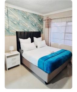 哈拉雷Beautiful 3-Bed House in Harare的一间卧室配有一张壁画床