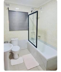哈拉雷Beautiful 3-Bed House in Harare的浴室配有卫生间、浴缸和水槽。