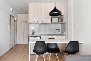 塞萨洛尼基#Aura Studios & Suites V9-10的厨房配有白色柜台周围的黑色椅子