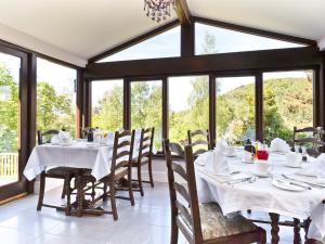 纽比桥希尔克雷斯特乡村旅馆的用餐室设有桌椅和窗户。