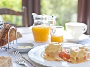 纽比桥希尔克雷斯特乡村旅馆的一张桌子,上面放着一盘早餐食品和橙汁